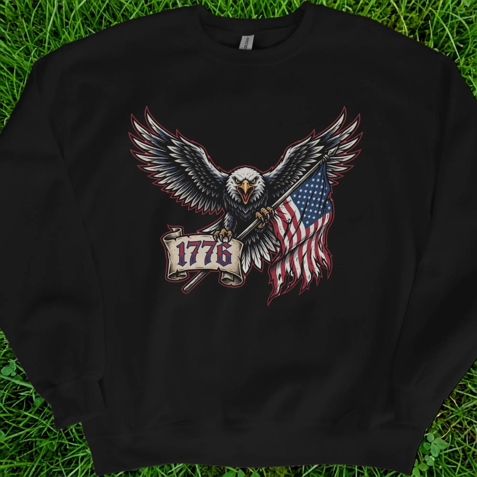 Eagle holding American flag and scroll with text "1776" on black sweatshirt.