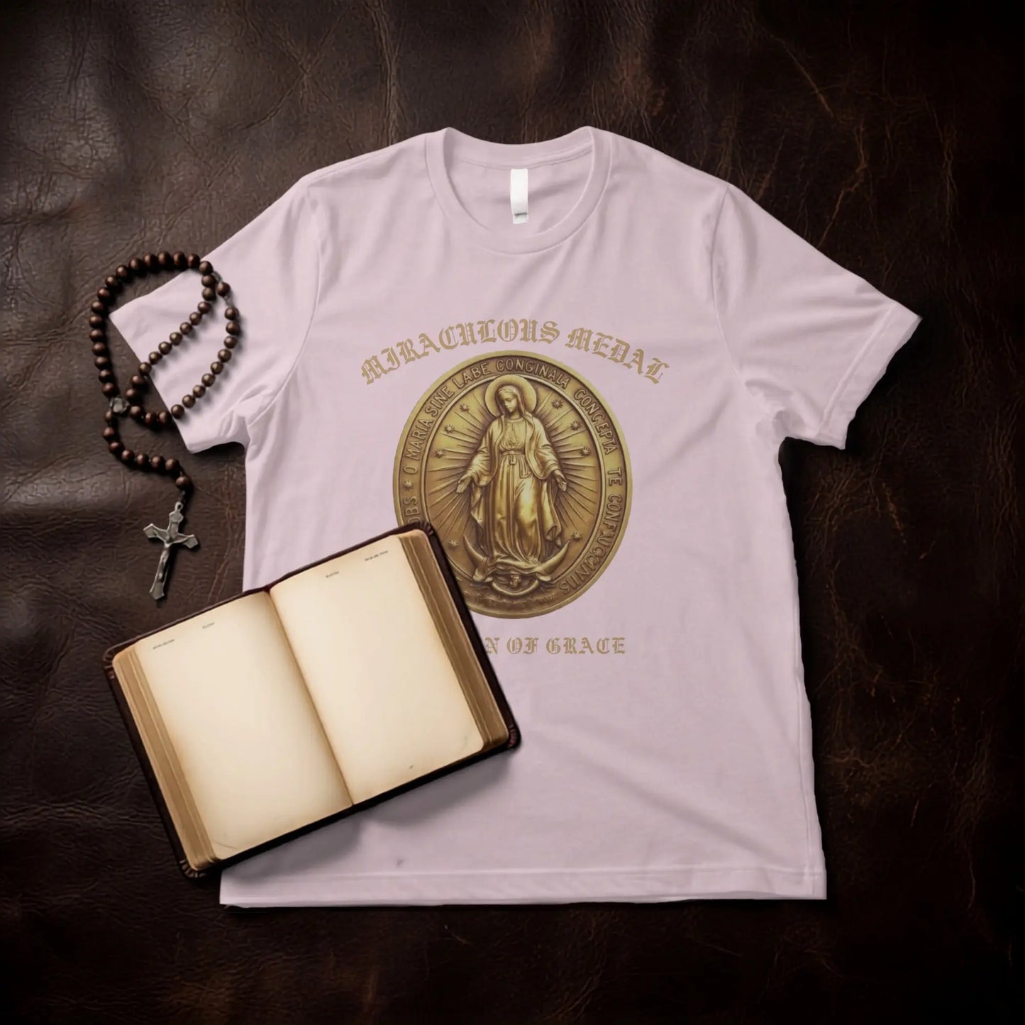 Pink t-shirt with a Miraculous Medal design and text above and below.