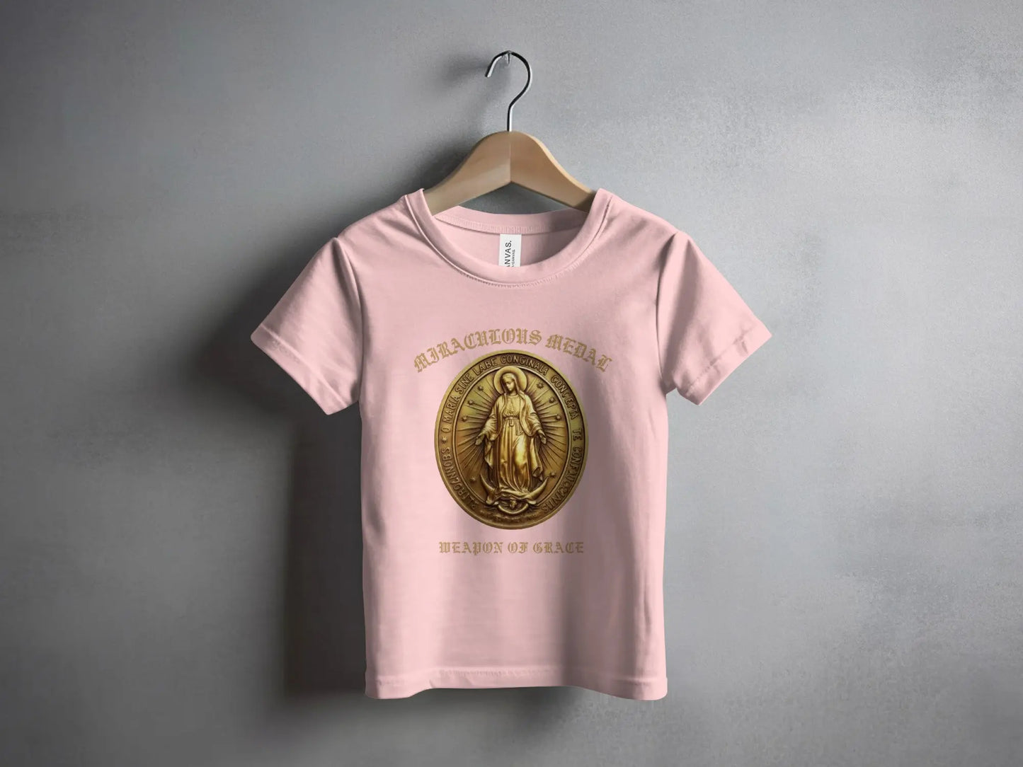 Pink t-shirt with a gold Miraculous Medal graphic that reads "Weapon of Grace."