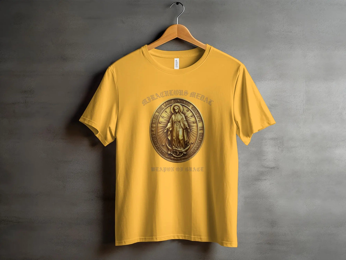 Yellow t-shirt with Miraculous Medal design and "Weapon of Grace" text.