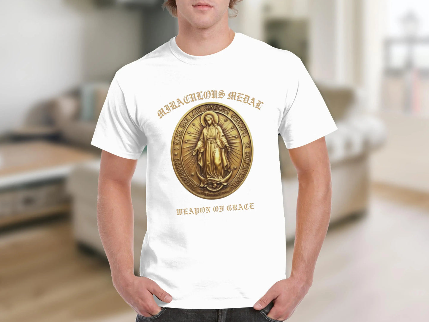 White t-shirt with a gold Miraculous Medal graphic and text "WEAPON OF GRACE".