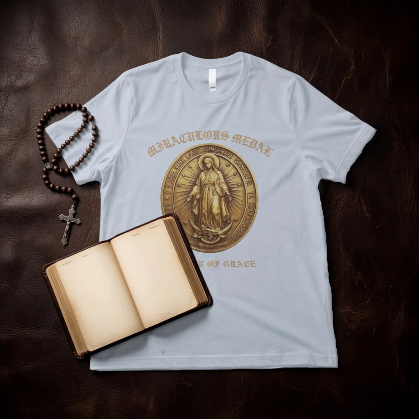 Light blue t-shirt with Miraculous Medal design, rosary, and open book.