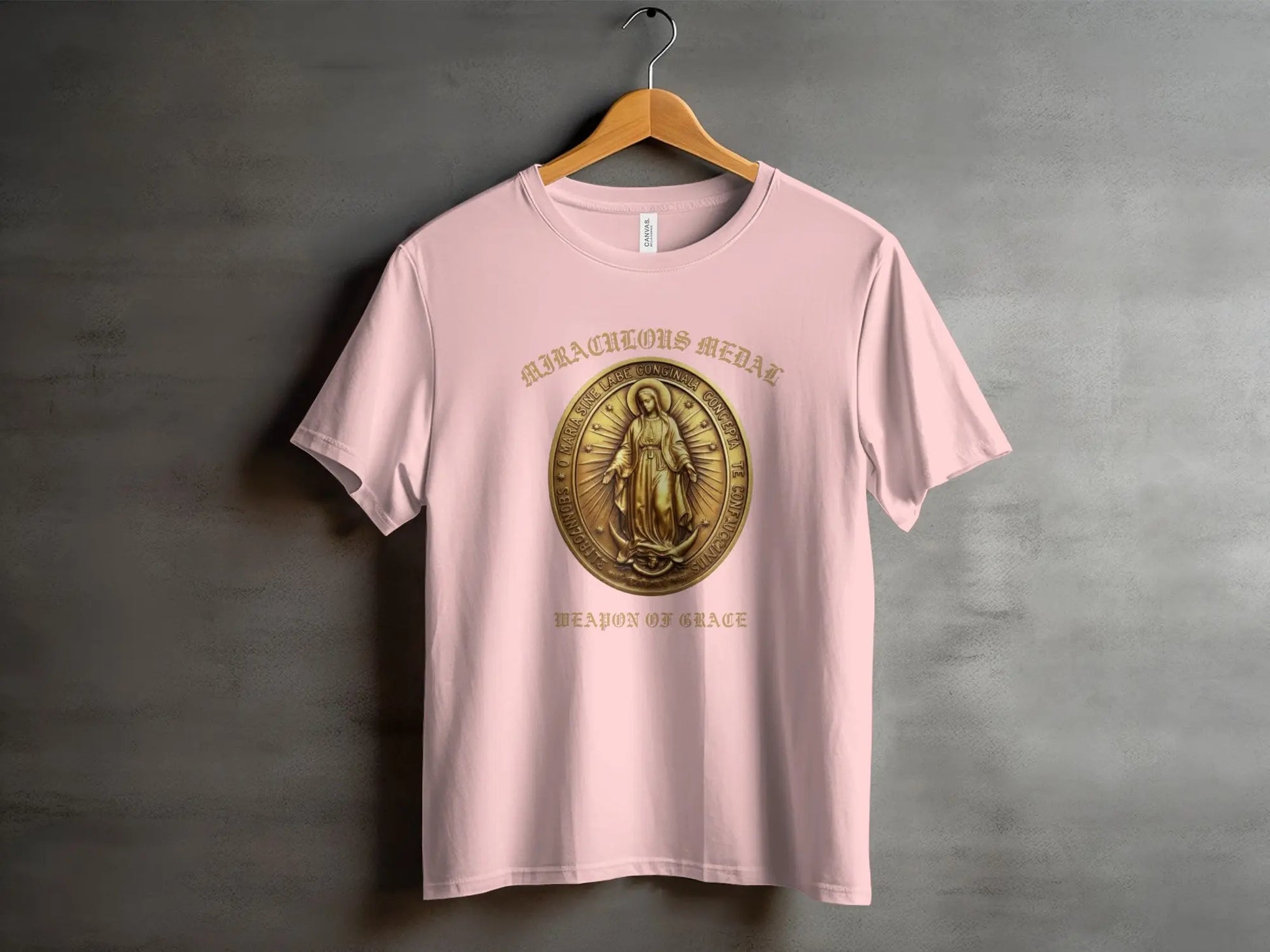 Pink t-shirt with "Miraculous Medal" and "Weapon of Grace" text and ornate medal design.