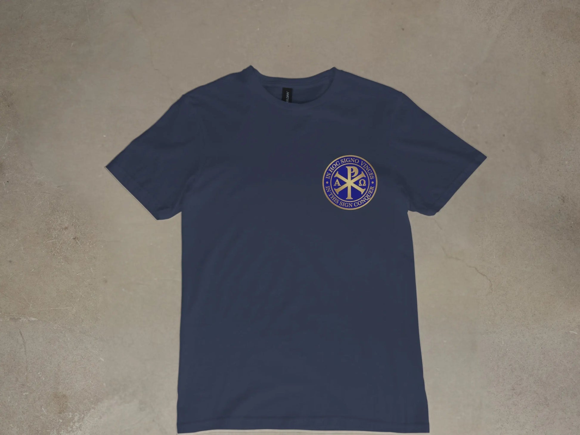 Navy t-shirt with gold Chi Rho symbol and Latin text.