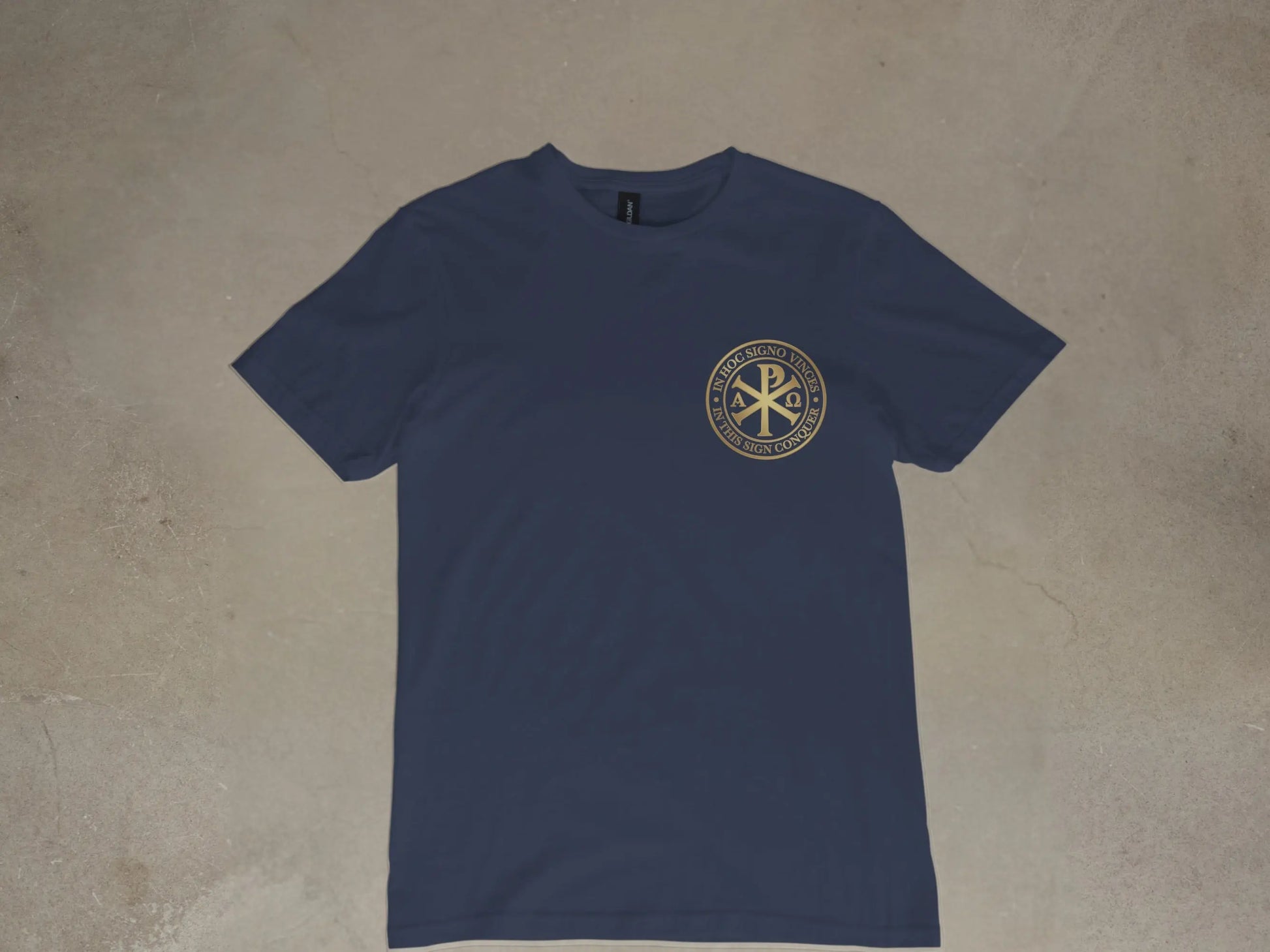 Navy t-shirt with gold Chi Rho symbol and Latin text "In Hoc Signo Vinces".