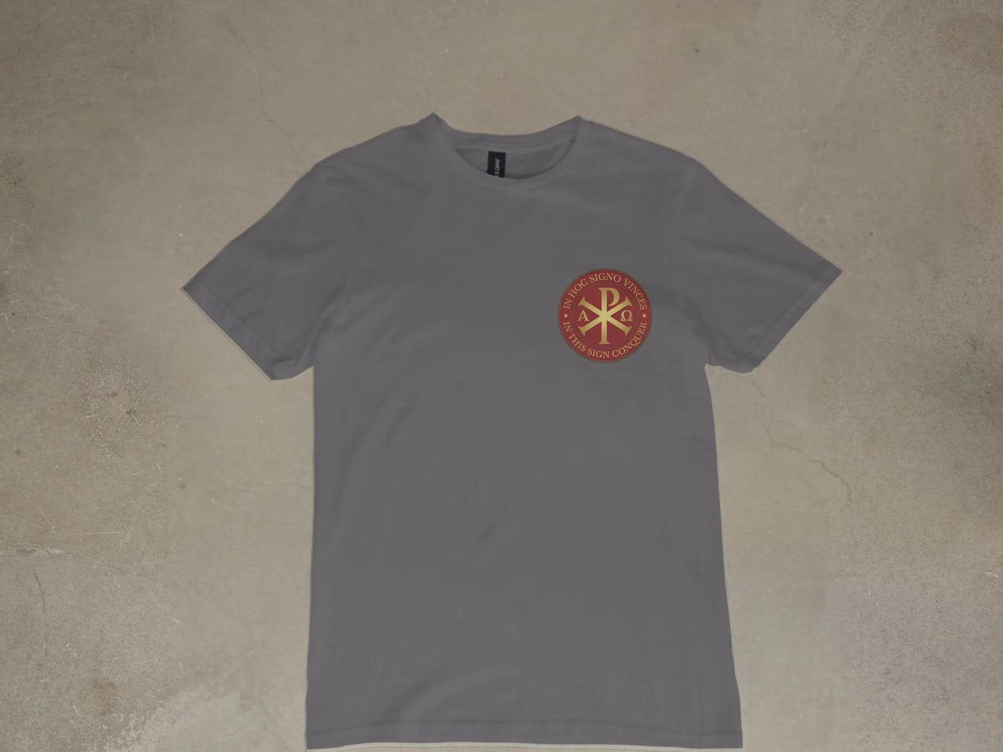 Grey t-shirt with circular emblem featuring Chi Rho symbol and Latin text.