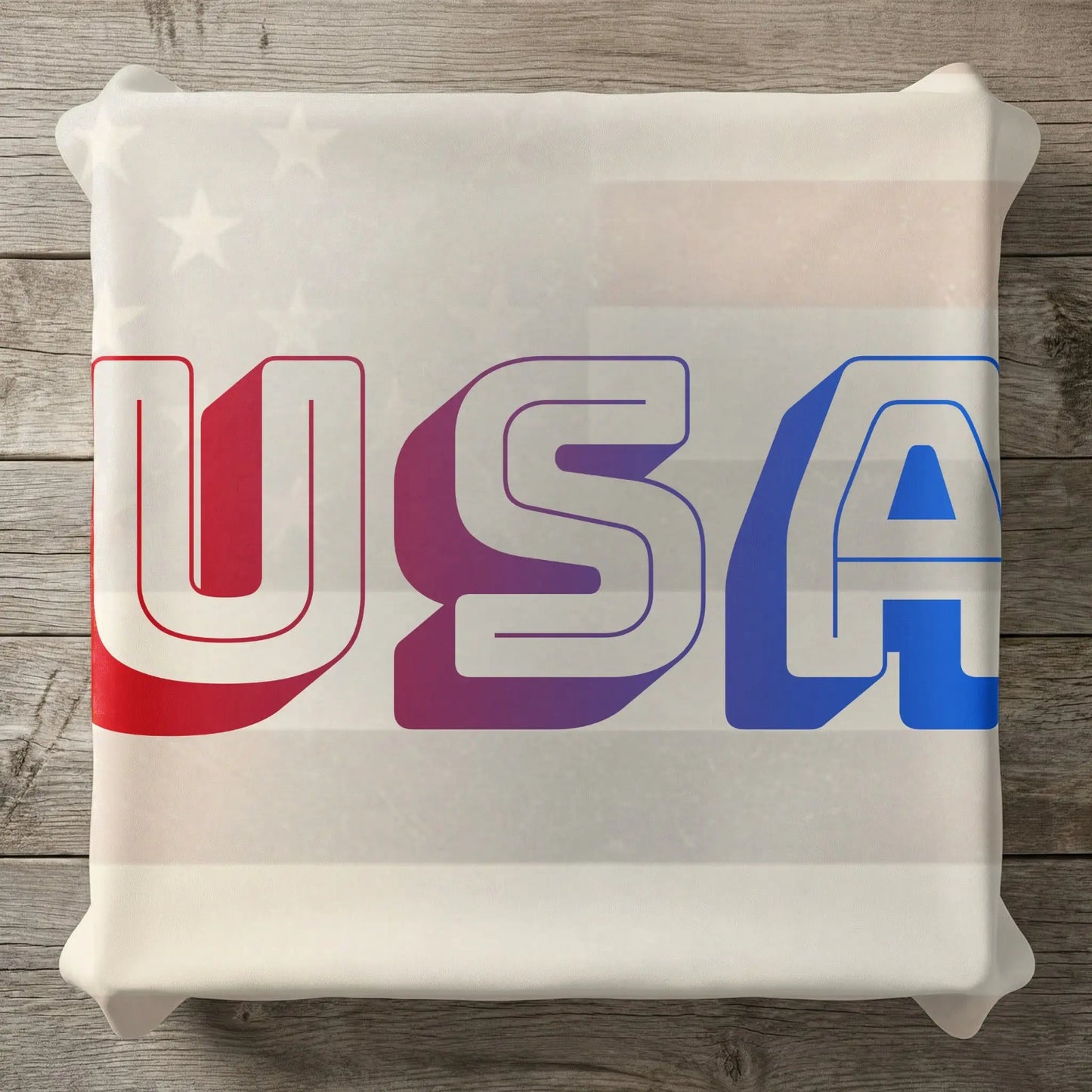 White pillow with red, purple, and blue "USA" text and subtle star pattern.
