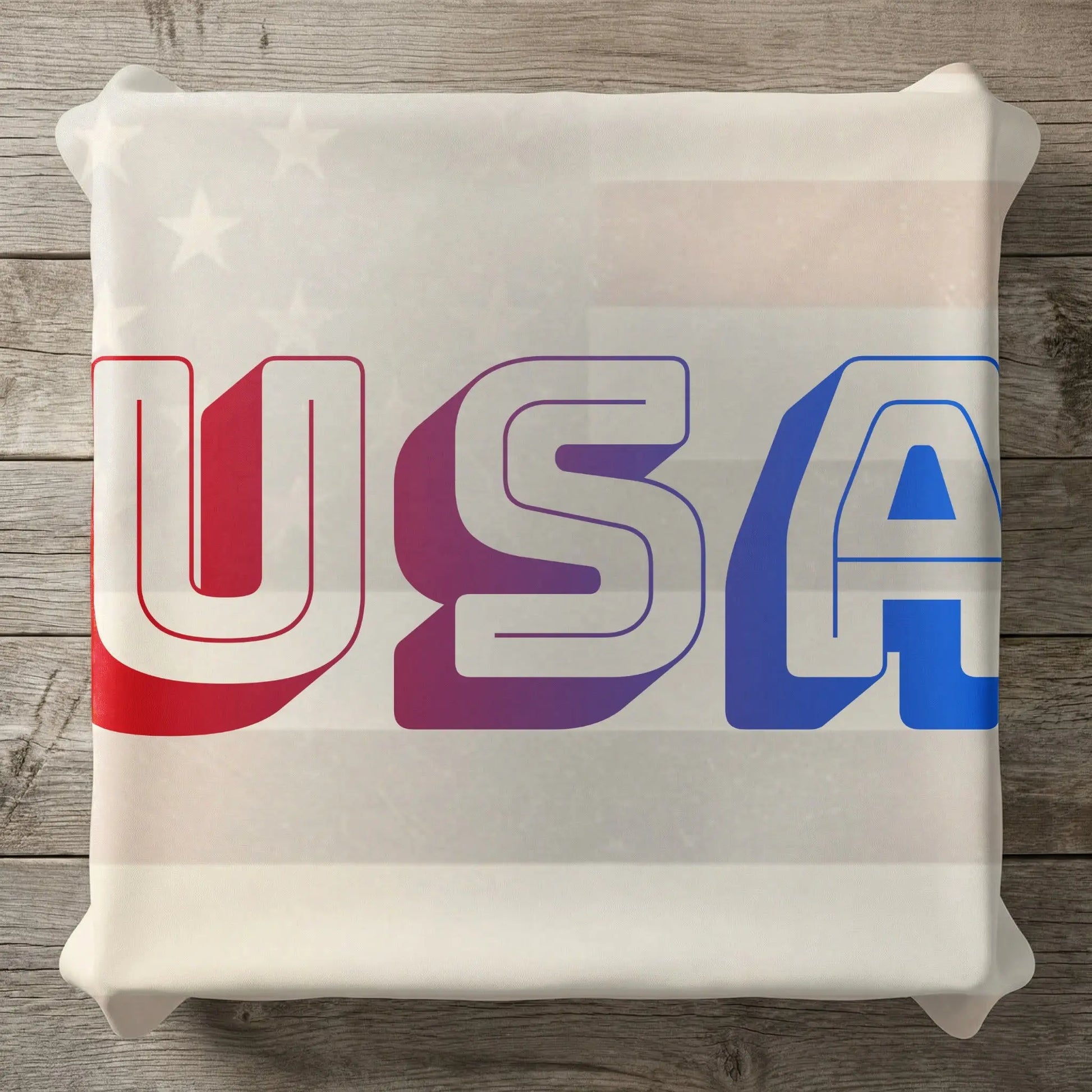 White pillow with red, purple, and blue "USA" text and subtle star pattern.