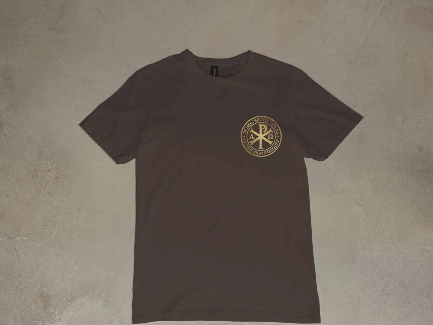 Brown t-shirt with gold circular emblem containing text and symbols.