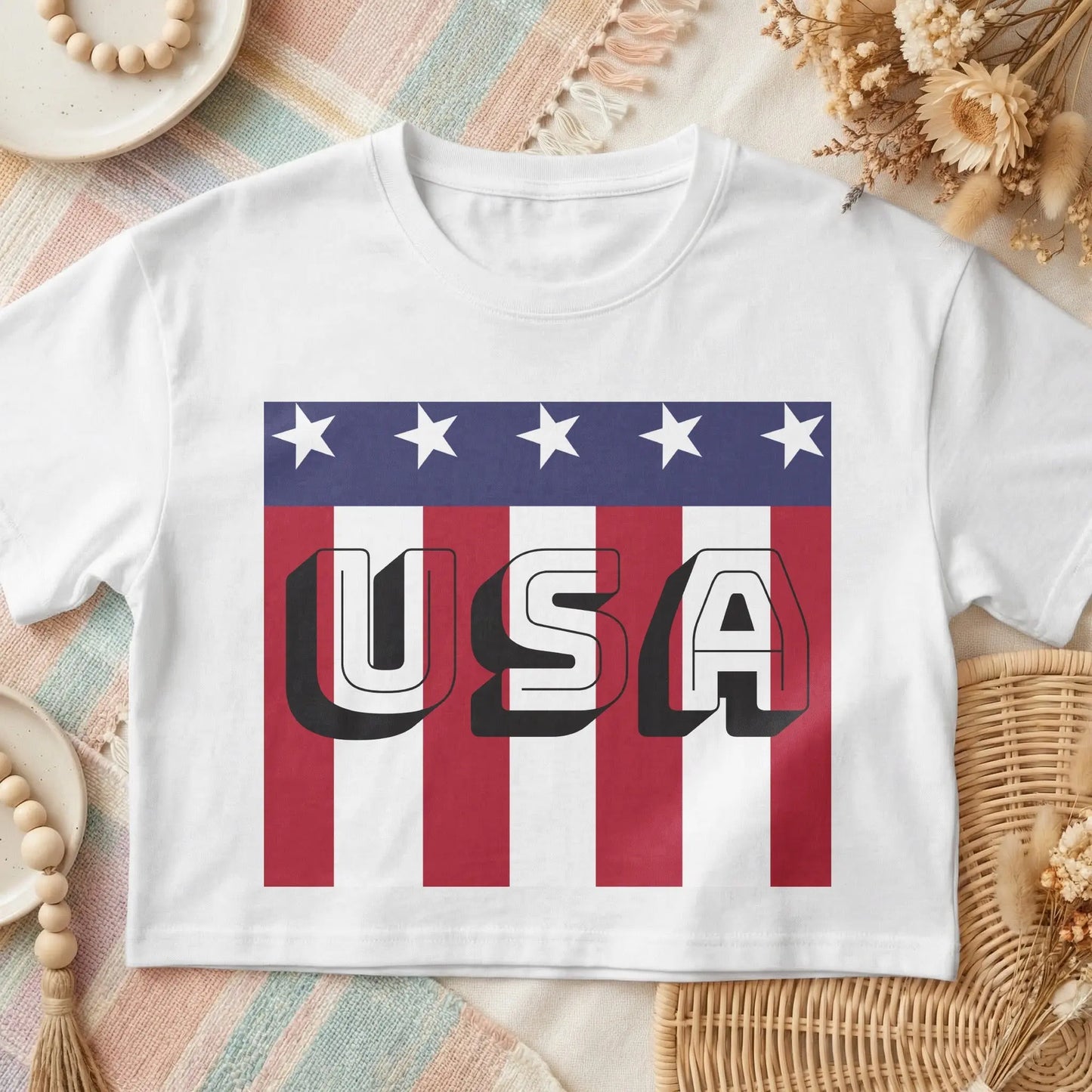 White t-shirt with bold "USA" text over American flag stripes and stars.
