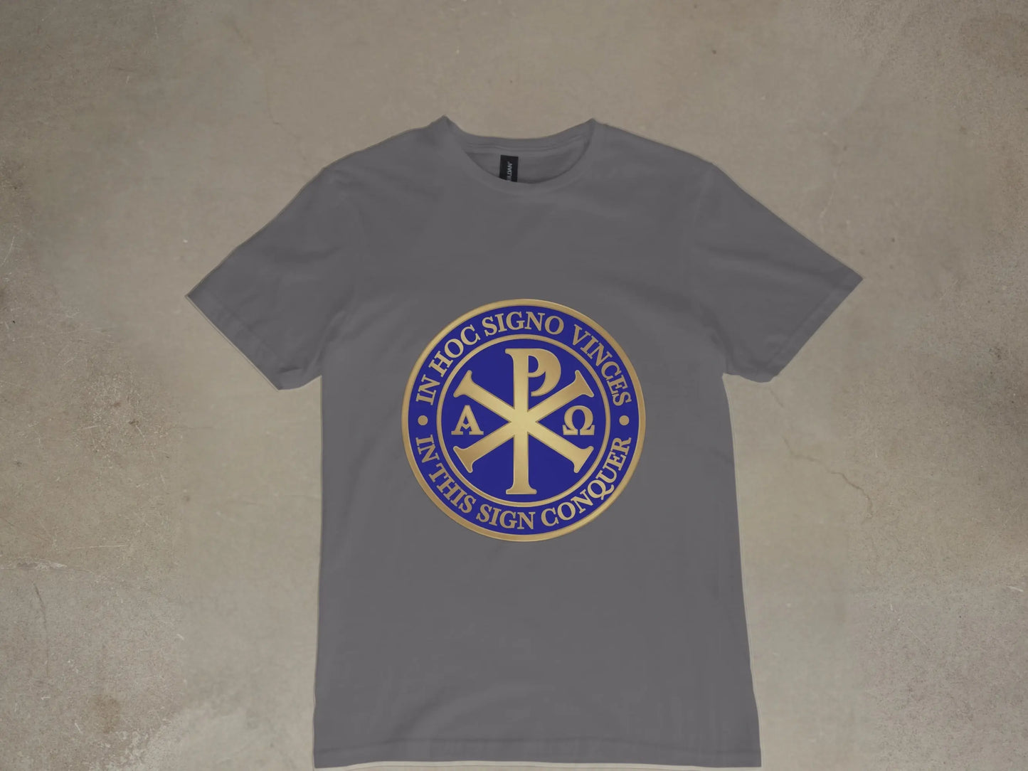 Grey t-shirt with a gold and blue circular emblem featuring the Chi Rho symbol and text.