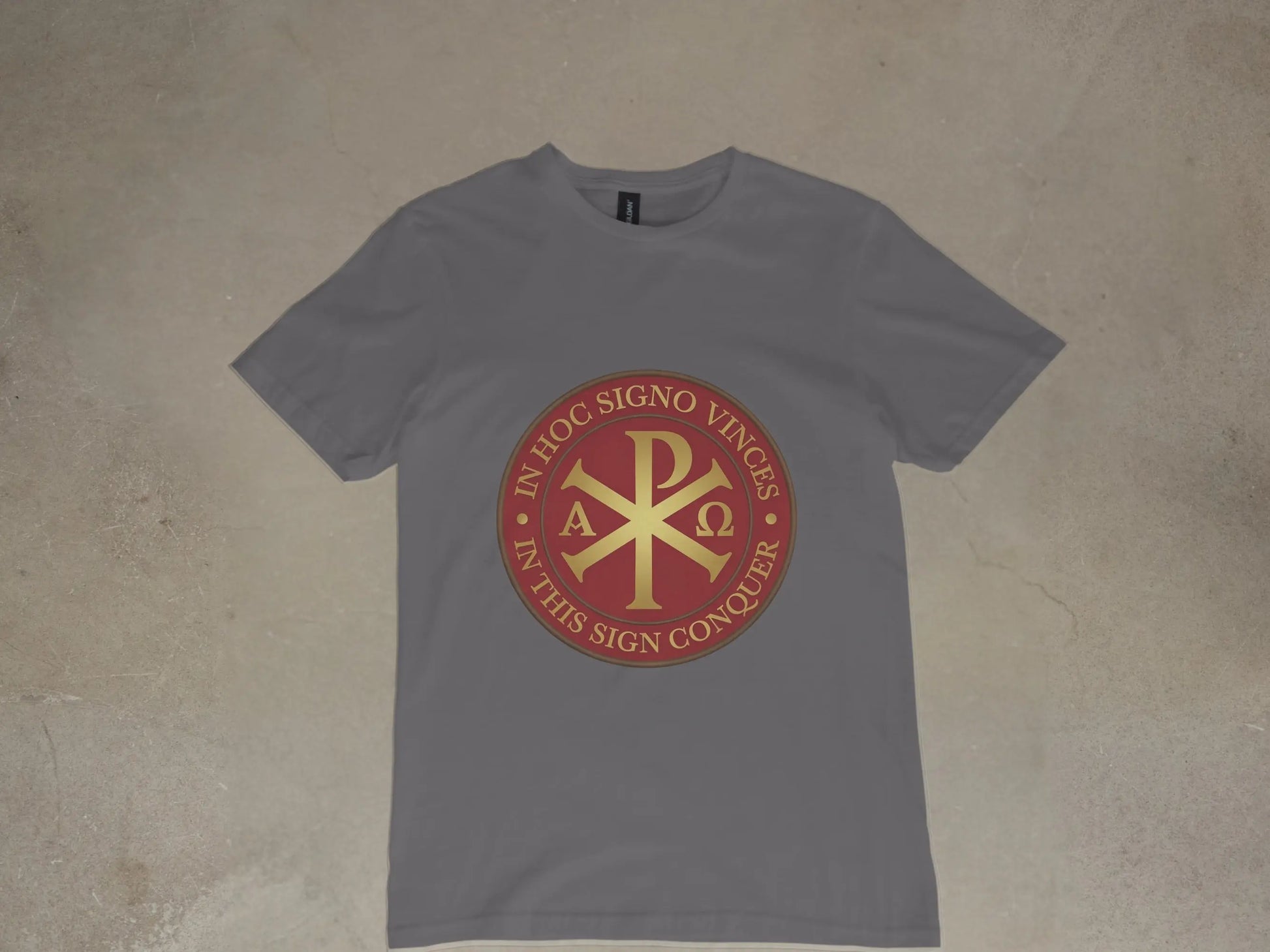 Grey t-shirt with a red and gold Chi Ro symbol and Latin text.