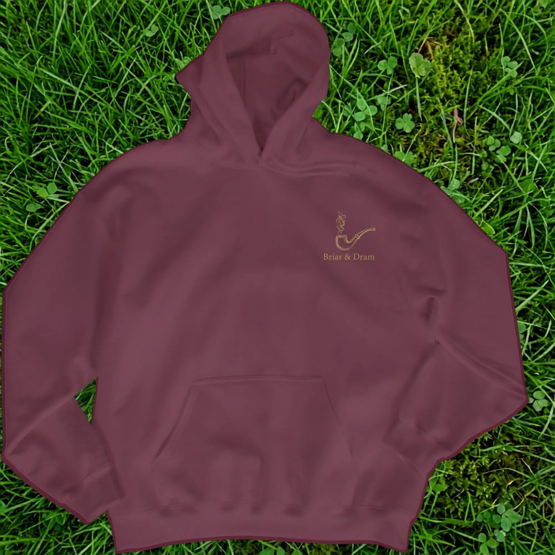 Maroon hoodie with a smoking pipe and text "Briar & Dram" on grass.