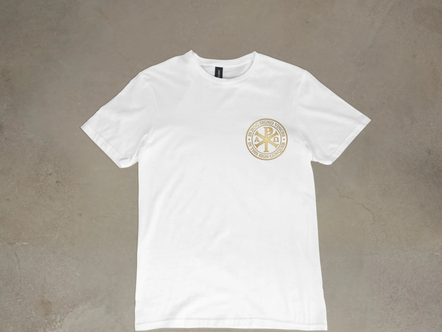 White t-shirt with gold circular emblem that reads "IN HOC SIGNO VINCES" and "IN THIS SIGN CONQUER".