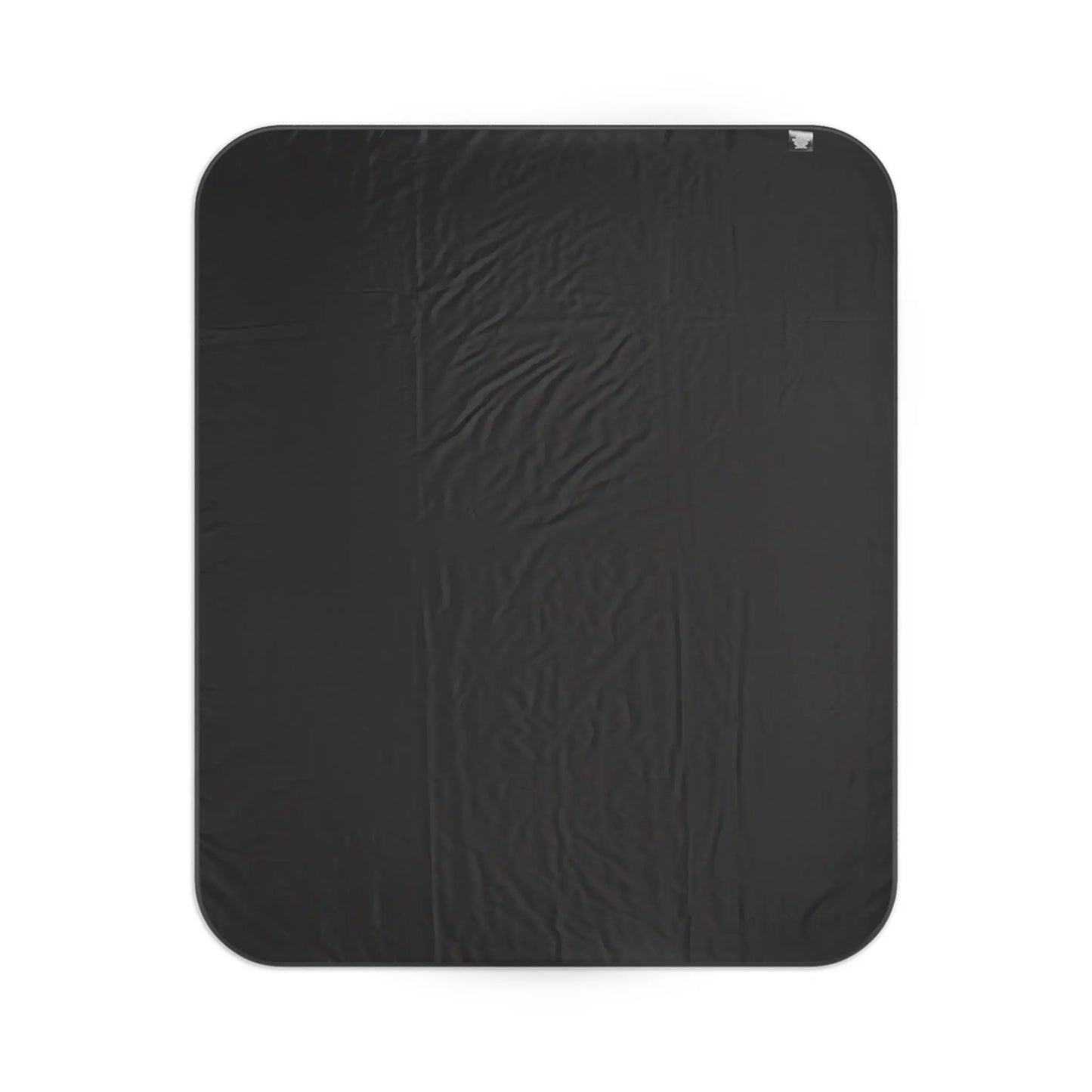 Black blanket with tag in upper right corner, laid flat.