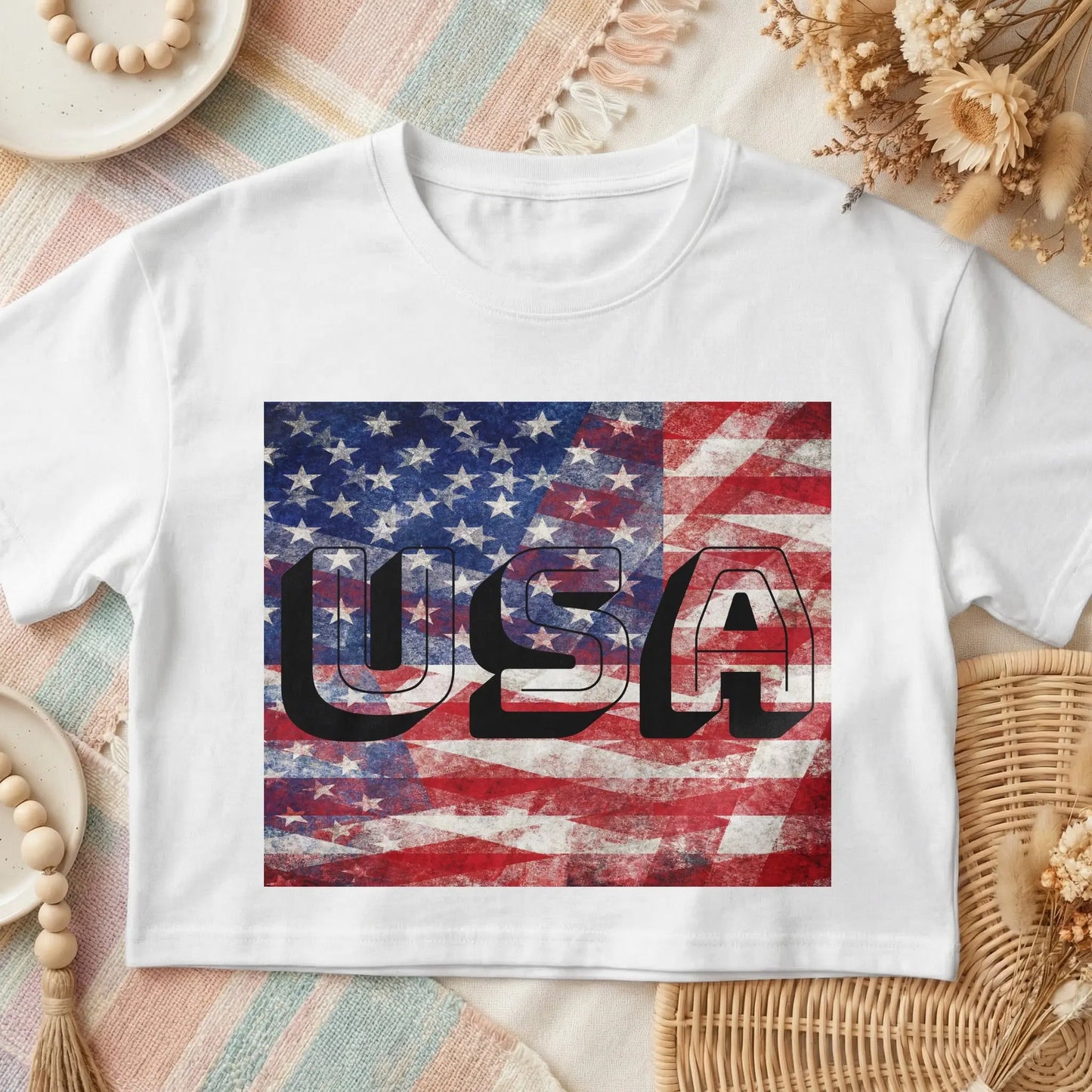 White t-shirt with "USA" text overlay on a distressed American flag graphic.