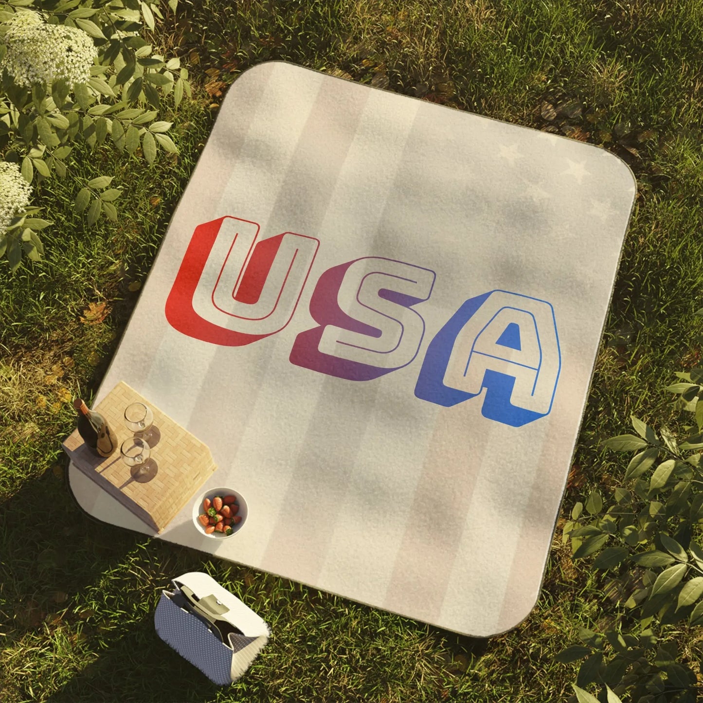 Picnic blanket with "USA" text, striped pattern, includes wine, glasses, and strawberries.